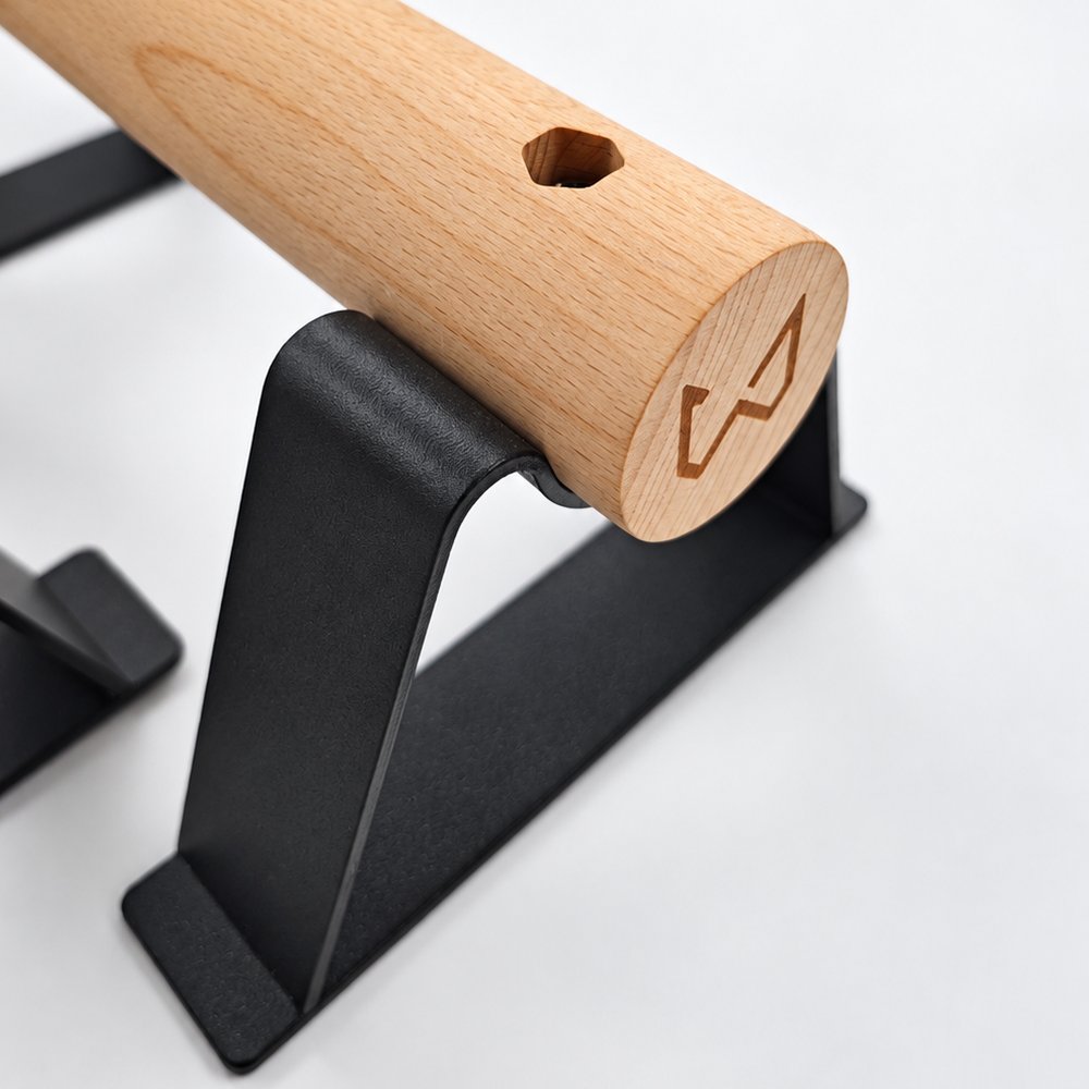 Detalle del mango de madera de haya con el logo grabado de Xtenia y el anclaje a la base de acero