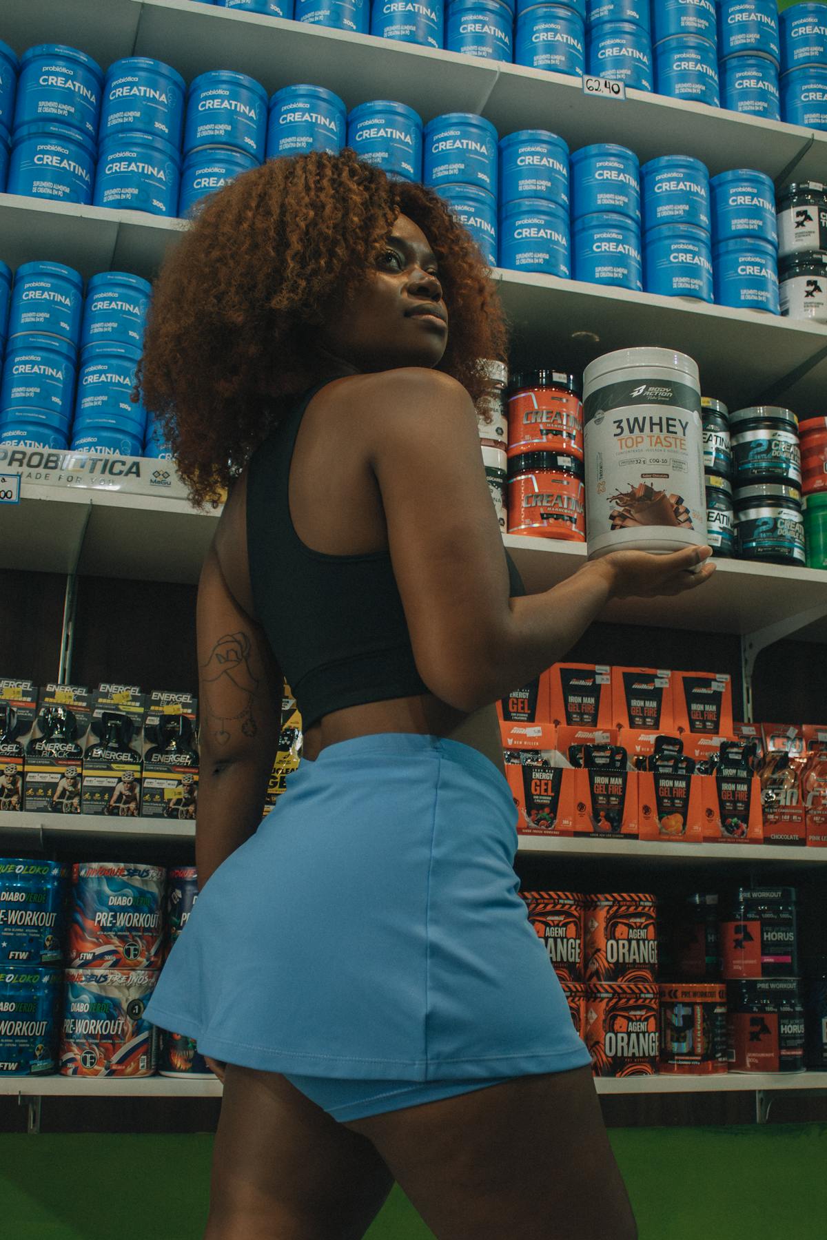 Persona con bote de suplemento en un entorno fitness